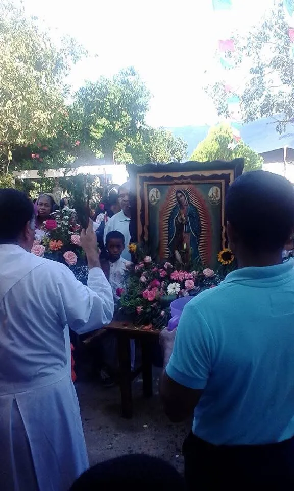 Procesión con la imagen de la Virgen de Guadalupe, flores y bendición del sacerdote